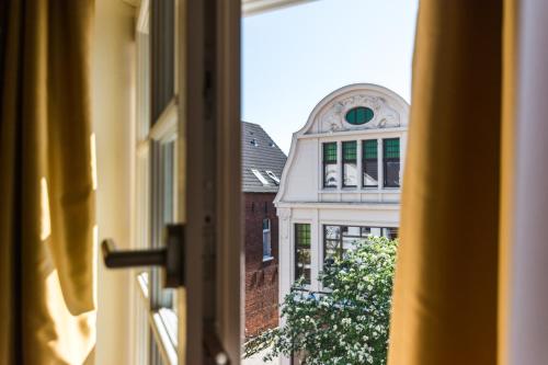 a view of a building from a window at Romantik Hotel Reichshof in Norden