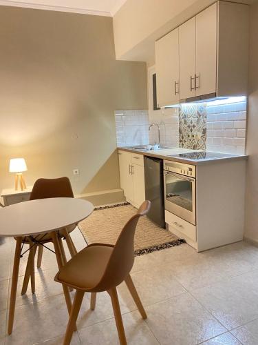 a kitchen with a table and two chairs and a table at Filoxenia Apartments in Mytilini