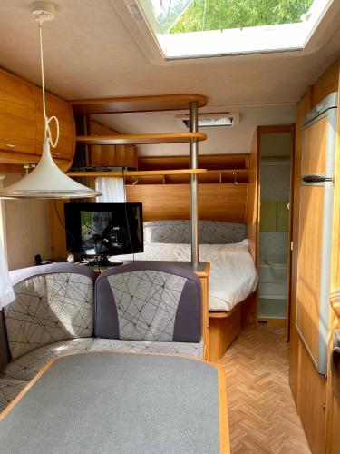 a small bedroom with a bunk bed and a tv at Słoneczne Przyczepy Dębki in Dębki
