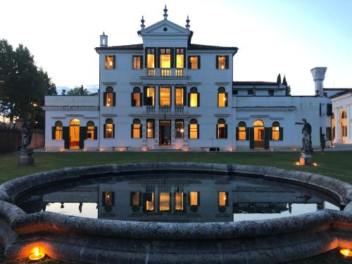uma grande casa branca com uma fonte em frente em Le Camere di Villa Cà Zenobio em Treviso