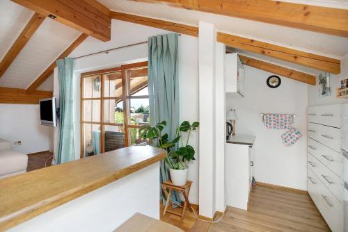 eine Küche und ein Wohnzimmer mit einer Theke und einem Fenster in der Unterkunft Josys Ferienwohnung in Gstadt am Chiemsee