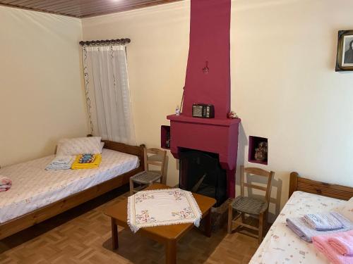 a small room with two beds and a fireplace at Villa Lochia - Mikrospilia House in Mikrospiliá