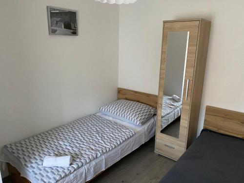 a small bedroom with two beds and a mirror at KLAPKA PROVANCE APARTMAN in Kaposvár