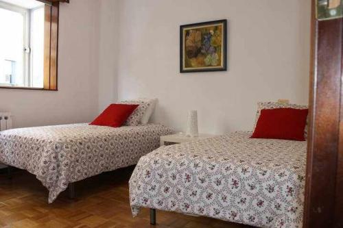 1 dormitorio con 2 camas y almohadas rojas en Amplio y luminoso apartamento en Villaviciosa en Villaviciosa