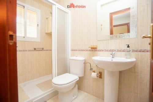un baño con inodoro y lavabo en El Anfitrión - Dúplex Doña Ana, en Sanlúcar de Barrameda