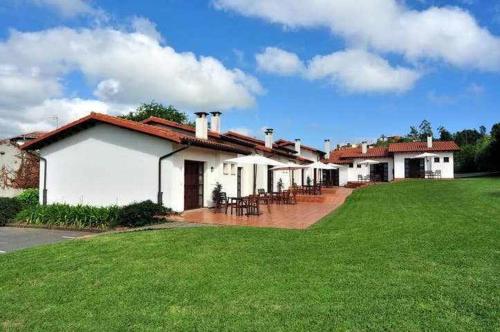 dom z zielonym trawnikiem przed nim w obiekcie Apartamento familiar cercano a playa de Rodiles 5 w mieście Villaviciosa