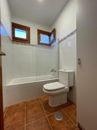 a bathroom with a toilet and a bath tub at Apartamento familiar cercano a playa de Rodiles. 6 in Villaviciosa