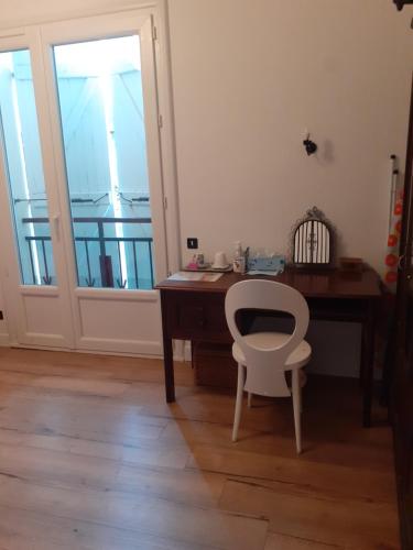 a desk and a chair in a room with a window at chambre au calme haute ville in Auch