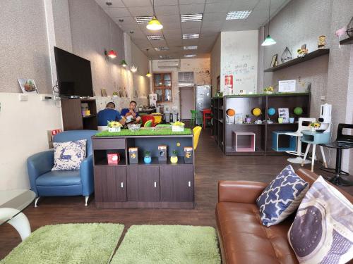 a living room with a couch and a person in a store at 花蓮阿羅國際青年旅舍民宿 in Hualien City
