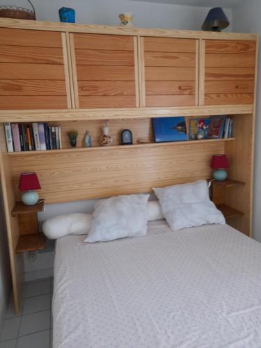 una camera con letto e testiera in legno di JOLI T2 RDC, BORD DE MER , PISCINE , Aresquiers FRONTIGNAN PLAGE 34 a Frontignan