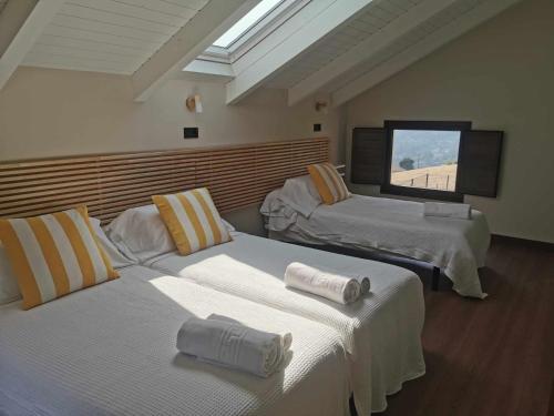 a room with two beds and a tv on the wall at La campa de Faedo-Tonin in Cudillero