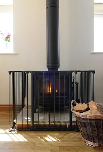 a fireplace in a living room with a basket at Mill Lane Farm Holiday Cottages in Lyndhurst