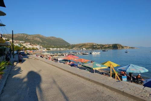 a shadow of a person walking down a beach with umbrellas at Royal 1967 in Himare