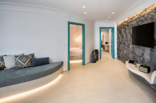 a living room with a couch and a flat screen tv at La Ponta Villas & Suites in Akrotiri