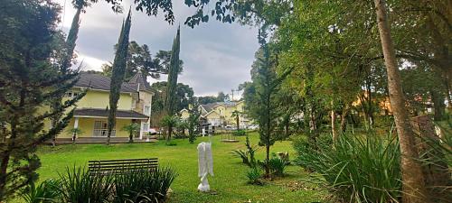 un parque con un banco frente a una casa en Pousada dos Anjos, en Canela