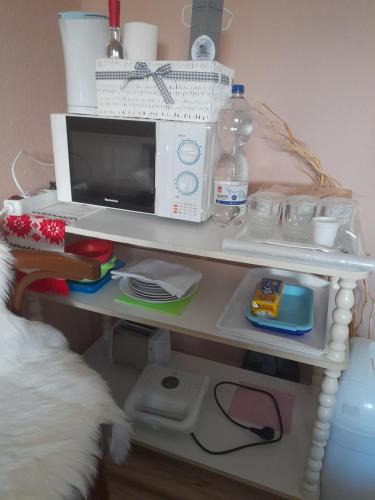 stół z kuchenką mikrofalową na górze w obiekcie Edit vendégház Szabolcsveresmart w mieście Szabolcsveresmart