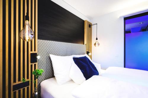 a bedroom with a bed with white and blue pillows at Aqua Blu Hotel in Bad Füssing
