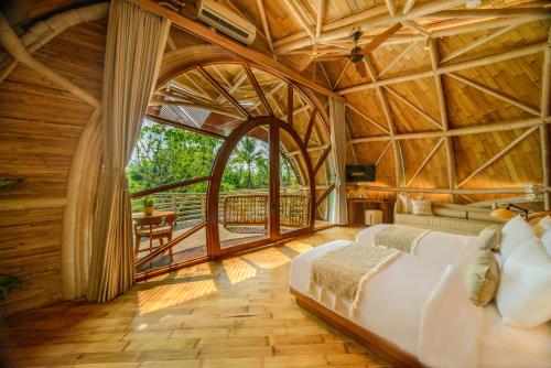 una camera da letto con un grande letto in una camera in legno di Ulaman Eco Luxury Resort a Tabanan