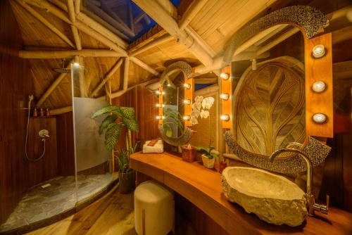 a bathroom with a sink and a large mirror at Ulaman Eco Luxury Resort in Tabanan