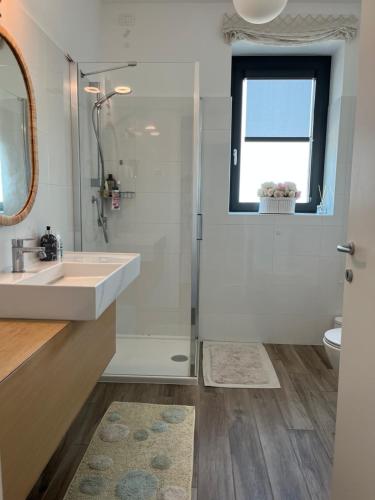 a bathroom with a sink and a shower and a window at Sweet Home in Milano smart district in Milan