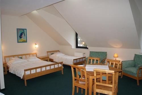 une chambre avec deux lits et une table et des chaises dans l'établissement PAN Dom Pracy Twórczej w Wierzbie, à Wierzba