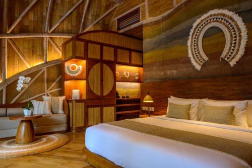 a bedroom with a bed and a couch in a room at Ulaman Eco Luxury Resort in Tabanan