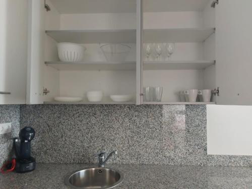 encimera de cocina con fregadero y armarios blancos en APARTAMENTO BRICIA 6, en Posada de Llanes