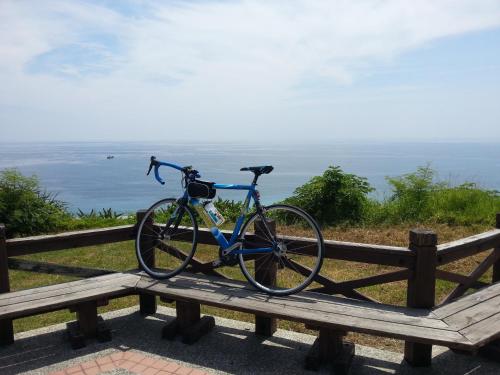 a bike parked on a wooden bench overlooking the ocean at 花蓮阿羅國際青年旅舍民宿 in Hualien City