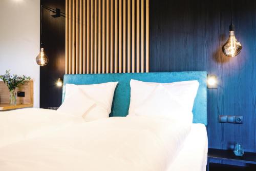 a bedroom with a large bed with a blue headboard at Aqua Blu Hotel in Bad Füssing