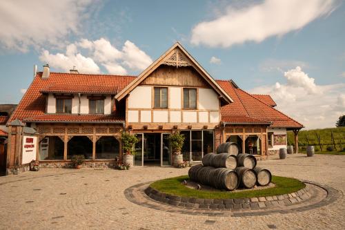 a house with a bunch of logs in front of it at Hotel Głęboczek Vine Resort& Spa in Wielki Głęboczek