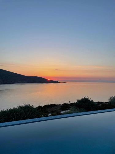 a view of a sunset over a body of water at Rock Bay Villas - Luxury Villas in Crete in Agia Pelagia