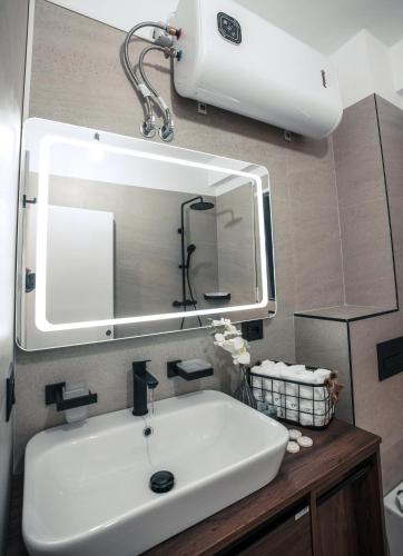 a bathroom with a white sink and a mirror at Mia Marine Rooms in Himare
