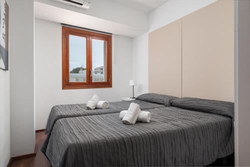 2 camas en una habitación blanca con ventana en Blau Blue 3, en Can Picafort