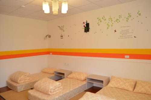 a room with two beds and a colorful wall at 花蓮阿羅國際青年旅舍民宿 in Hualien City
