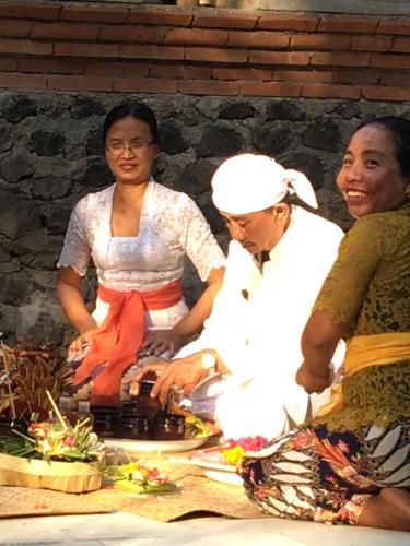 a group of people standing around a table with food at Rumah Kelapa Villa Alami in Karangasem