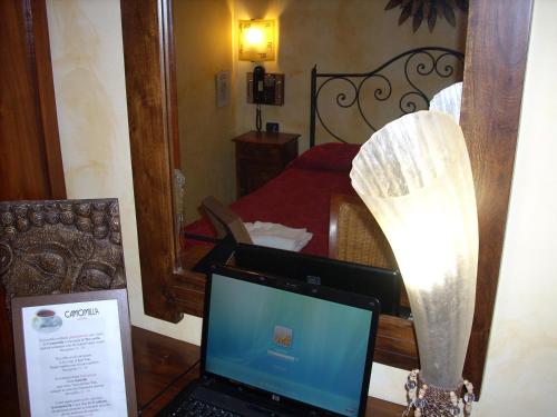 einen Laptop auf einem Schreibtisch neben einem Schlafzimmer in der Unterkunft Viennese Due in Rom