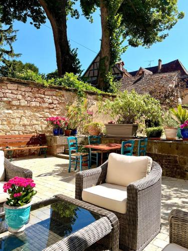 a patio with wicker chairs and a table at Chambres d'Hôtes du Marché aux Grains in Bouxwiller