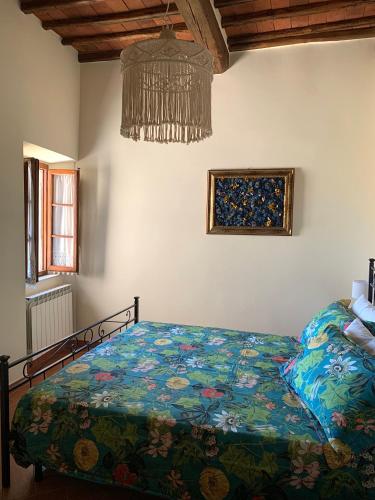 a bedroom with a bed and a chandelier at Dolcevita Chianti Apartments in Radda in Chianti