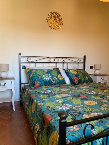 a bedroom with a bed with a floral comforter at Dolcevita Chianti Apartments in Radda in Chianti