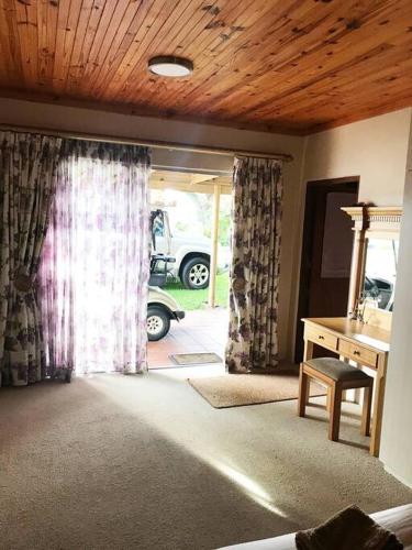 a living room with a sliding glass door with a car outside at Sedgefield Lagoon Hideout - Kingfisher Drive in Sedgefield