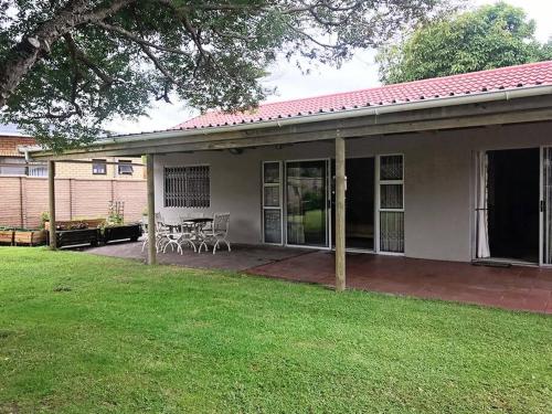 a house with a patio with a table and chairs at Sedgefield Lagoon Hideout - Kingfisher Drive in Sedgefield
