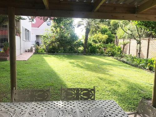a backyard with a lawn with a table and chairs at Sedgefield Lagoon Hideout - Kingfisher Drive in Sedgefield