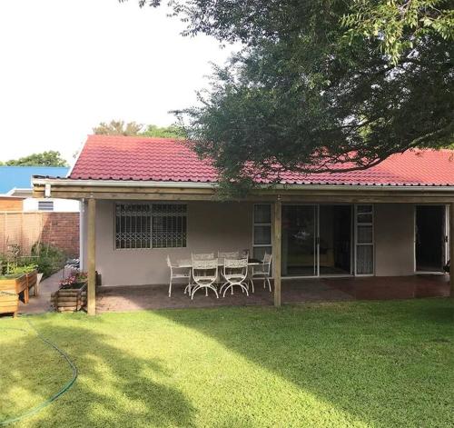 a house with a table and chairs in the yard at Sedgefield Lagoon Hideout - Kingfisher Drive in Sedgefield