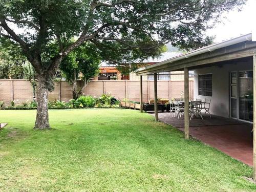 a yard with a tree and a house at Sedgefield Lagoon Hideout - Kingfisher Drive in Sedgefield
