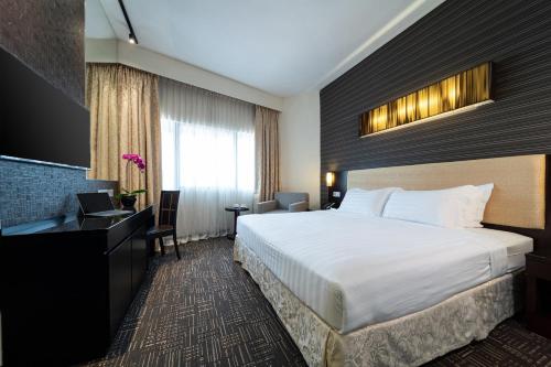 a hotel room with a bed and a desk at Hotel Royal Queens in Singapore