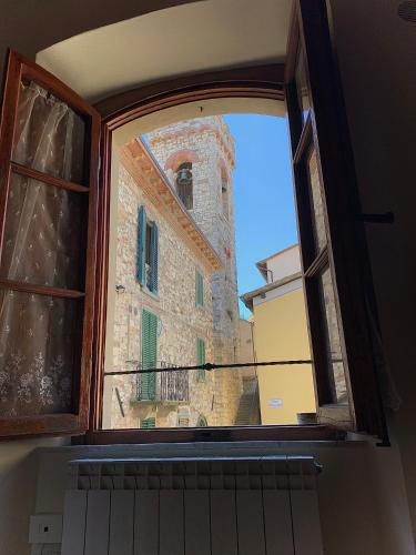 an open window of a building with a tower at Dolcevita Chianti Apartments in Radda in Chianti