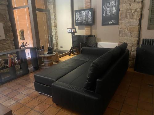 a black leather couch in a living room at Habitació polivalent al centre de Manresa in Manresa