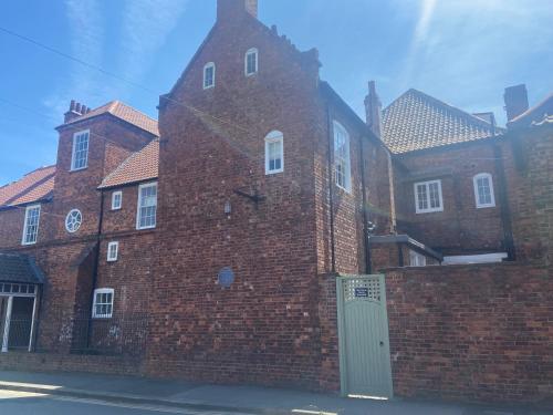 a large brick building with a gate and a brick wall at Red Barns Bed & Breakfast in Redcar