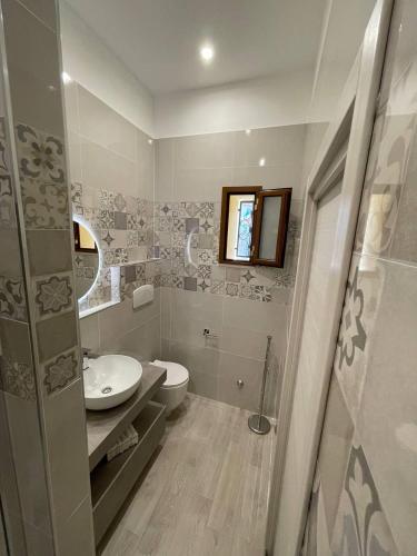 a bathroom with a sink and a toilet and a mirror at Il Vicoletto - Tassitani Vacanze in Corigliano Calabro