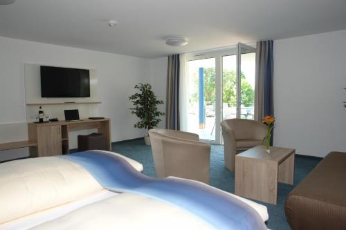 a hotel room with a bed and a tv at CAP Rotach in Friedrichshafen